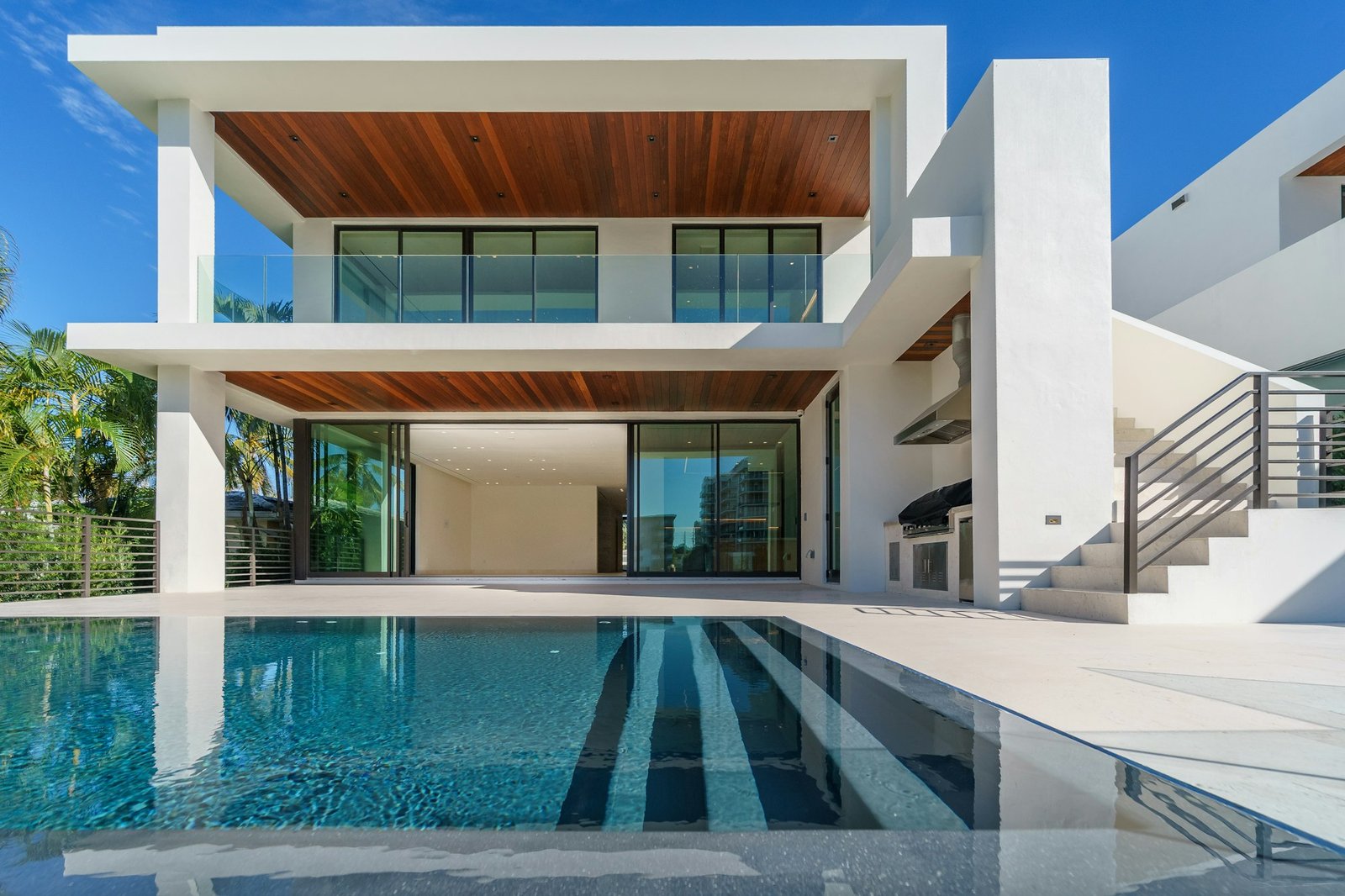 Contemporary villa with floor-to-ceiling glass doors opening onto a pool terrace